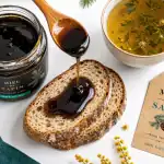 Miel de sapin bienfaits : pot sombre, miel sirupeux et tisane tiède